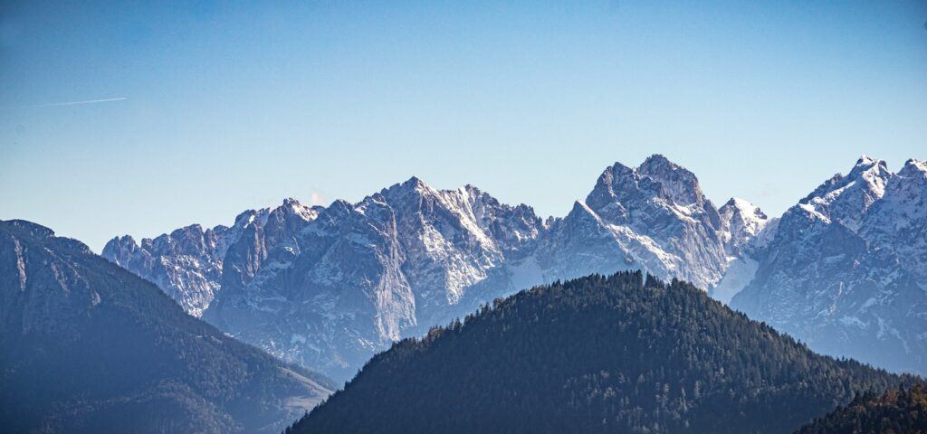 a view of a mountain range with trees in the foreground