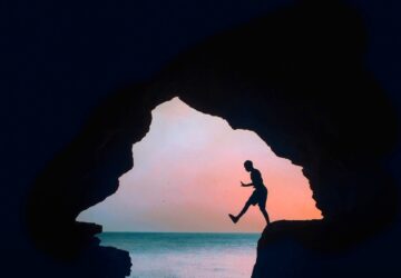 silhouette photography of a man on cliff