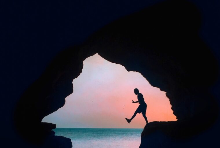 silhouette photography of a man on cliff