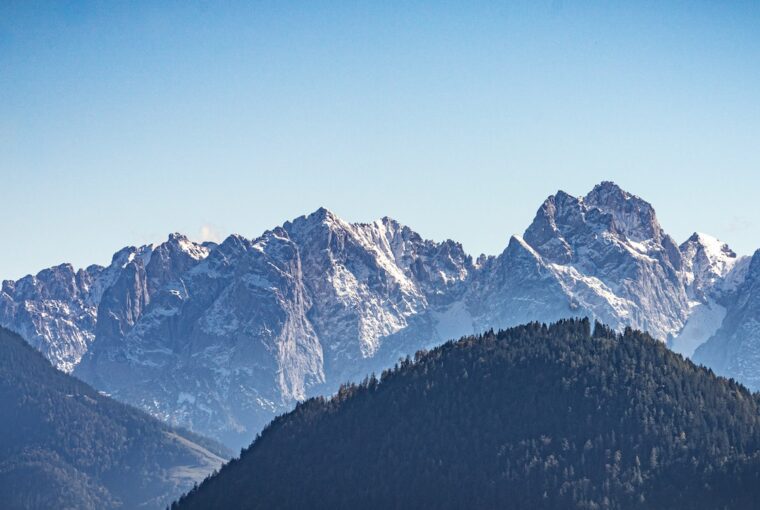 a view of a mountain range with trees in the foreground